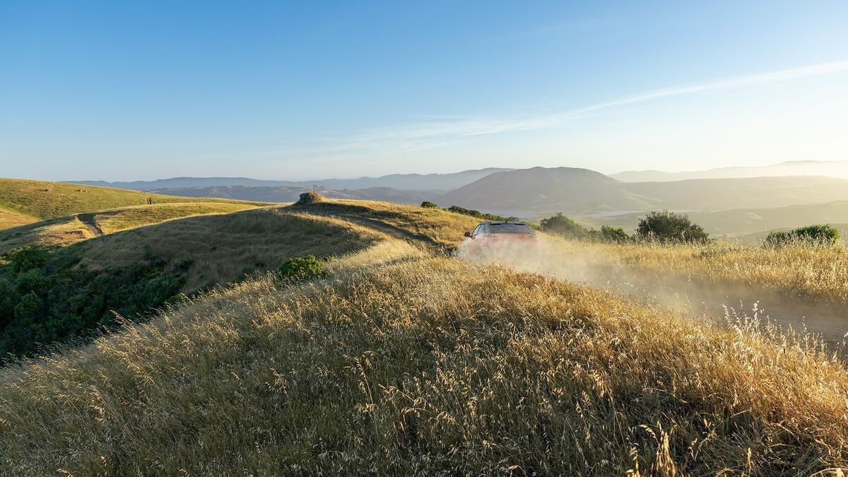 A teaser photo showing the 2026 Subaru Uncharted from the rear obscured by dust