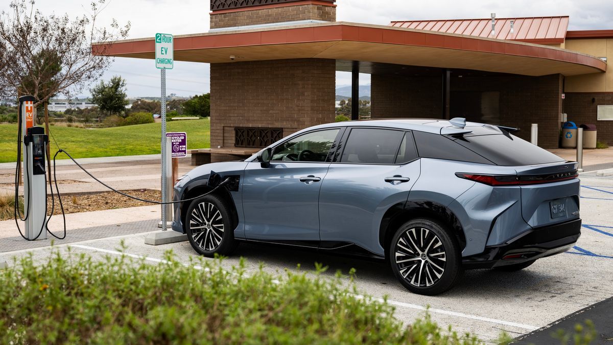 The 2025 Lexus RZ 450e seen from a rear quarter angle plugged in to charge