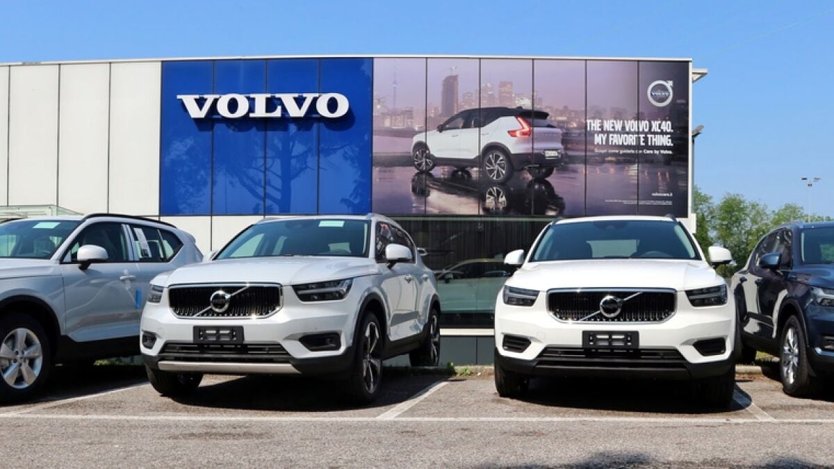 Three Volvo vehicles parked outside a dealership beneath an advertisement
