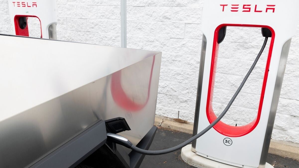 A Tesla Cybertruck plugged in to a Tesla Supercharger to charge