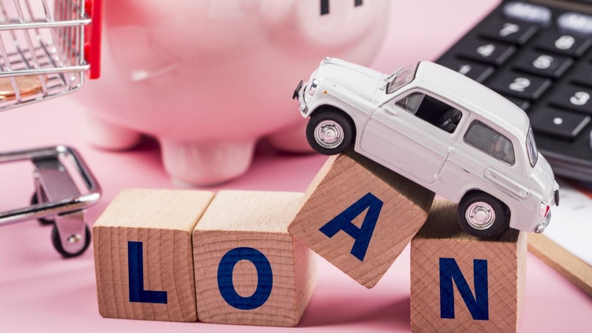 A toy Fiat sits atop blocks spelling out the word Loan