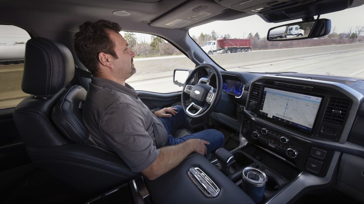 A test driver with his hands off the wheel using Ford's BlueCruise hands-free highway driving assist system