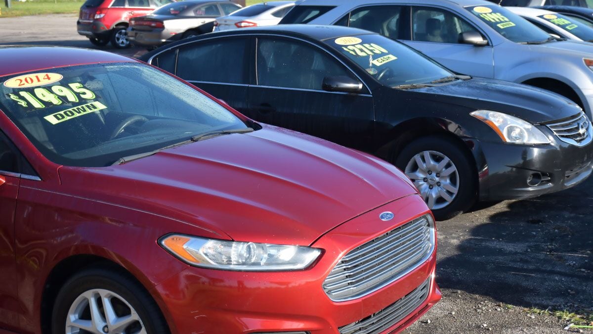 A line of used cars from several brands at a dealership