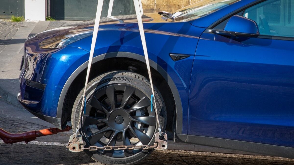 A pre-facelift Tesla Model Y with some signs of damage is towed after an accident