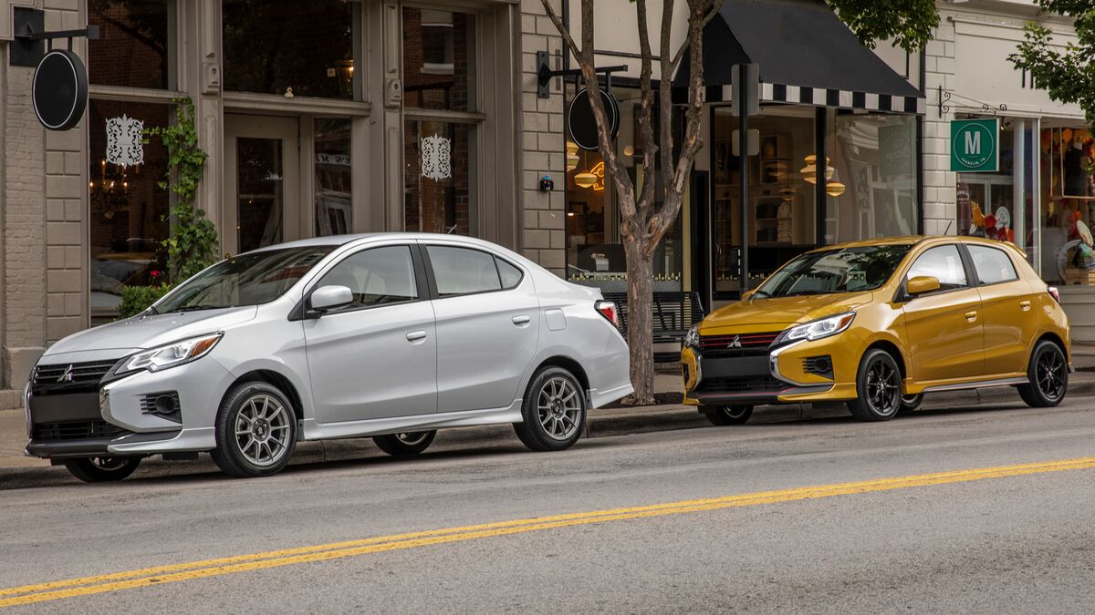 A pair of Mitsubishi Mirages, a sedan in white and a hatchback in yelllow