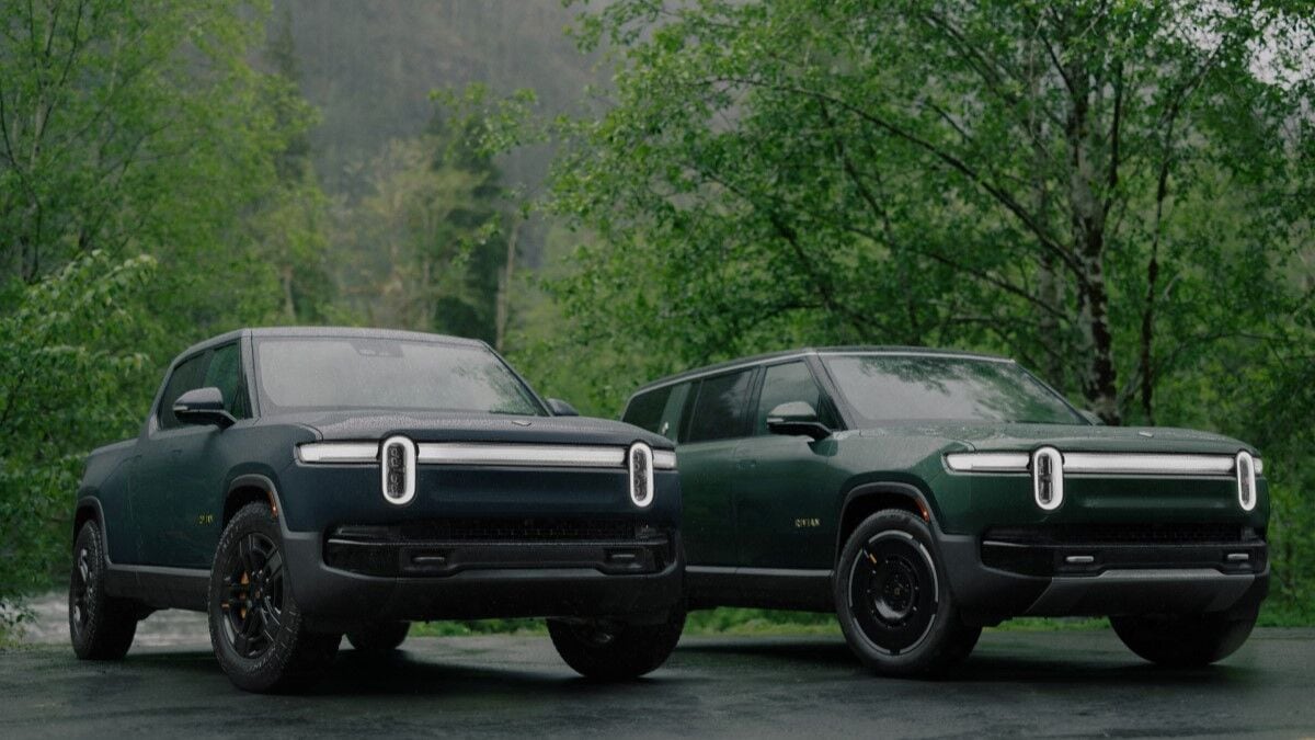 The 2025 Rivian R1T (in blue) and R1S (in green) seen from a front quarter angle