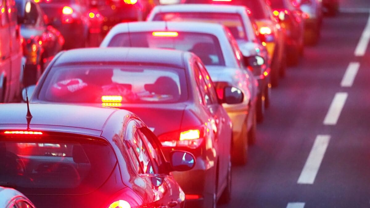 Cars lined up in bumper-to-bumper traffic with their brake lights on
