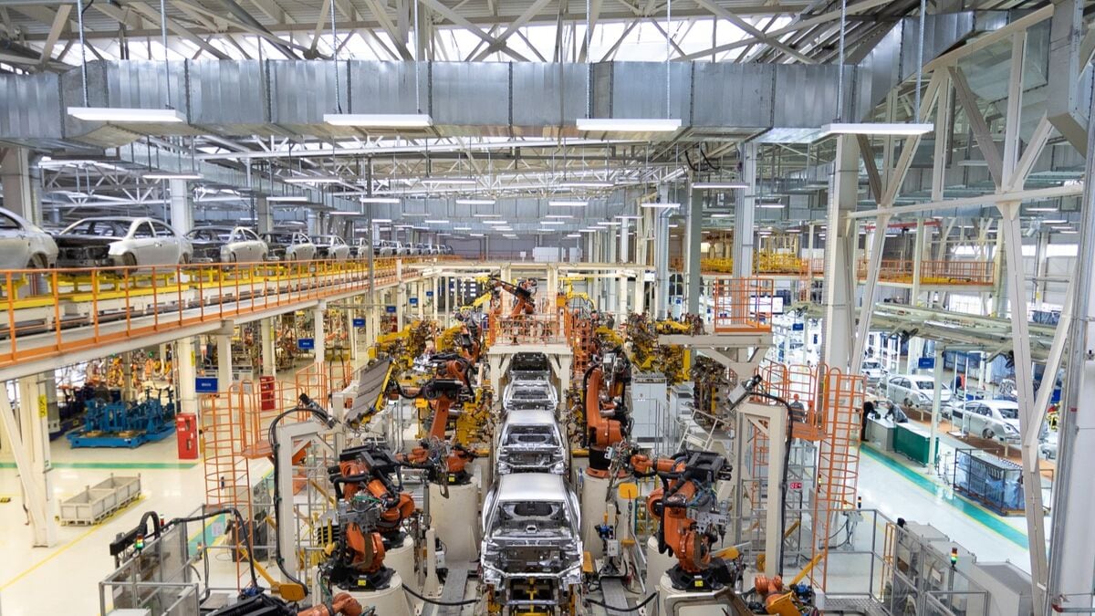 Cars moving down an assembly line in a factory seen from overhead