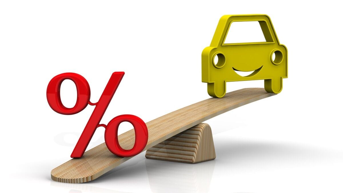 A toy car sits on a teeter-totter with a percentage sign