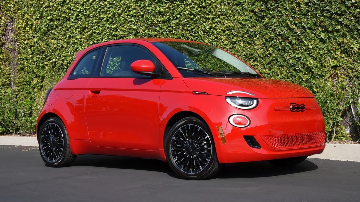 2024 Fiat 500e in red parked next to an ivy wall.