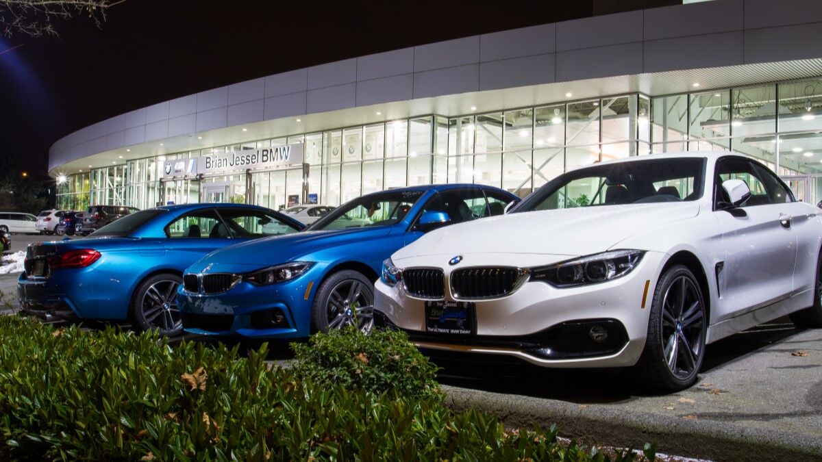 Cars lined up for sale outside a BMW dealership at night